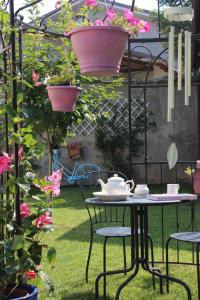 un tavolo e sedie in un giardino fiorito di Albero della vita a Cuneo