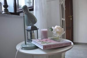 een tafel met een boek en een lamp en een kaars bij Albero della vita in Cuneo