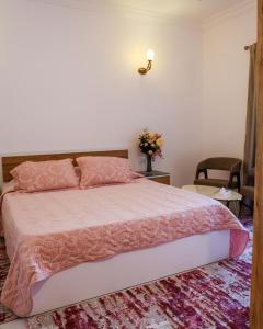 a bedroom with a large bed with a pink comforter at Reef Zefta Hotel in Zefta