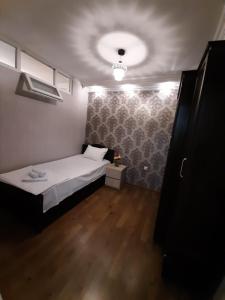 a small bedroom with a bed and a ceiling at Two-Bedroom Apartment in Tbilisi in Tbilisi City +4 photos