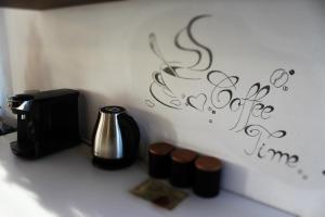 a counter with a coffee pot and a wall with writing at Casa Retro Toplița in Topliţa