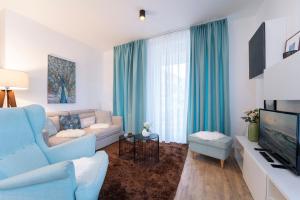 een woonkamer met een blauwe bank en een tv bij KellenHus Wohnung 3 in Kellenhusen