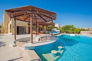 a swimming pool with a wooden pavilion next to a house at 4 Bed El Gouna Villa in Hurghada