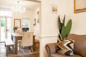 a living room and dining room with a couch and a table at Chester Racecourse Townhouse in Chester