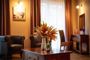 a room with a table with a vase of flowers on it at Maya Panzio in Szeged