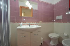 a bathroom with a sink and a toilet and a mirror at Appartamenti da Clarissa in Macari