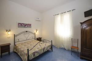a bedroom with a bed and a dresser and a window at Appartamenti da Clarissa in Macari