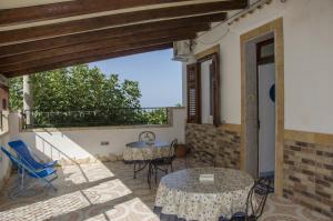 eine Terrasse mit Tischen und Stühlen sowie einen Balkon in der Unterkunft Appartamenti da Clarissa in Macari