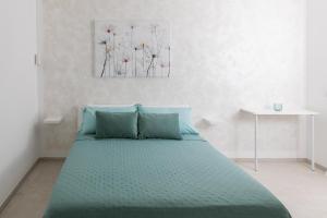 a bedroom with a bed with a green comforter at Pietra Fiorita Dimora in Conversano