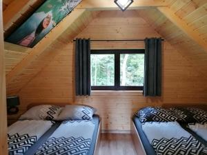 two beds in the attic of a log cabin at Agroturystyka W oddali z balią in Międzylesie