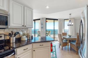 a kitchen and dining room with a view of the ocean at Phoenix Vll 1002 in Orange Beach