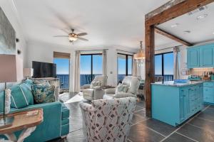 a living room with blue furniture and a view of the ocean at Phoenix Vll 1401 in Orange Beach