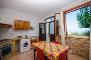 a kitchen with a table with red chairs and a window at Appartamenti da Clarissa in Macari