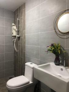 a bathroom with a toilet and a sink and a mirror at Cozy 2BR APT @Ampang Embassy Row in Kuala Lumpur