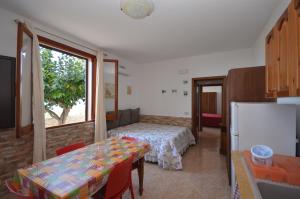 a room with a table and a bed and a window at Appartamenti da Clarissa in Macari