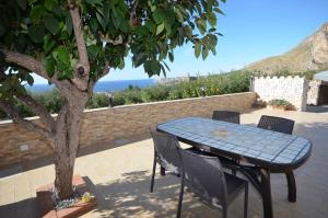 a table and chairs on a patio with a tree at Appartamenti da Clarissa in Macari