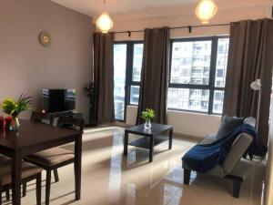 a living room with a table and chairs and windows at Cozy 2BR APT @Ampang Embassy Row in Kuala Lumpur
