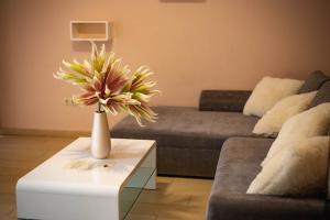 a living room with a vase of flowers on a table at Maya Panzio in Szeged