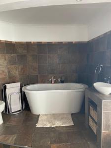 ein Badezimmer mit einer weißen Badewanne und einem Waschbecken in der Unterkunft Karoo Heart in Beaufort West