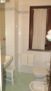 a white bathroom with a sink and a toilet at Residenza Turistico Alberghiera Corallo in Castiglione della Pescaia