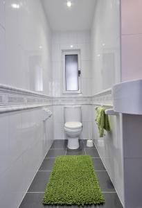 グジラにあるAzure Haven - Gzira Apartments and Penthouse By ShortLetsMaltaのバスルーム(白いトイレ、緑のラグ付)
