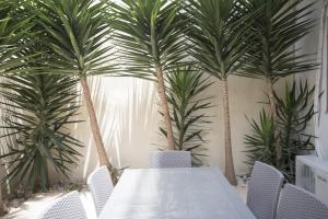 グジラにあるAzure Haven - Gzira Apartments and Penthouse By ShortLetsMaltaの部屋にある椅子とテーブルとヤシの木