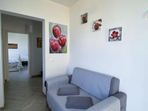 a living room with a couch and a painting of red balloons at Appartamenti da Clarissa in Macari