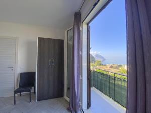 a room with a balcony with a view of the ocean at Appartamenti da Clarissa in Macari
