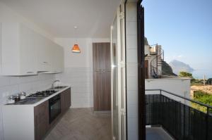 a kitchen with white appliances and a balcony at Appartamenti da Clarissa in Macari