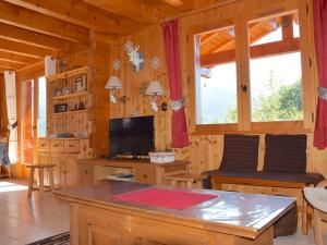 a living room with a table and a tv in a cabin at Chalet Bernex, 7 pièces, 16 personnes - FR-1-498-39 in Bernex