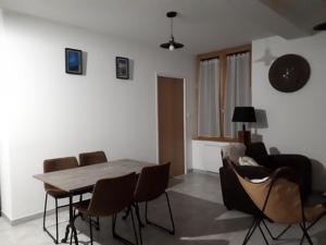 a living room with a wooden table and chairs at Appartement Mont-Dore, 3 pièces, 4 personnes - FR-1-415-77 in Le Mont-Dore