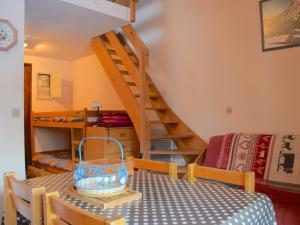 a dining room with a table and a staircase at Studio Bernex, 1 pièce, 4 personnes - FR-1-498-36 in Bernex