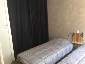 a bedroom with two beds and a black curtain at Appartement Mont-Dore, 3 pièces, 4 personnes - FR-1-415-77 in Le Mont-Dore