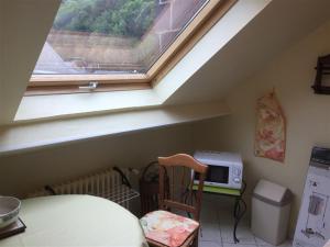 勒蒙多爾的住宿－Appartement Mont-Dore, 2 pièces, 2 personnes - FR-1-415-83，厨房设有窗户、桌子和微波炉