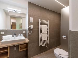 a bathroom with a sink and a toilet and a mirror at Gasthof Schöntal in Oberau