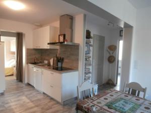 uma cozinha com armários brancos, uma mesa e uma cama em Appartement Capbreton, 4 pièces, 8 personnes - FR-1-239-484 em Capbreton