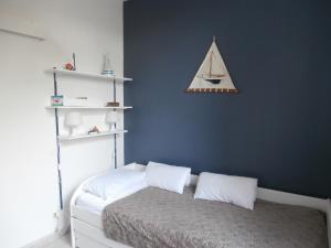 ein Schlafzimmer mit einem Bett mit einer blauen Wand in der Unterkunft Charmant T3 de standing à Capbreton, jardin, 3 chambres, terrasse couverte, proche port et plages - FR-1-239-484 in Capbreton