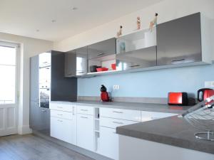 una cocina con armarios blancos y una pared azul en Appartement Évian-les-Bains, 4 pièces, 6 personnes - FR-1-498-48 en Évian-les-Bains
