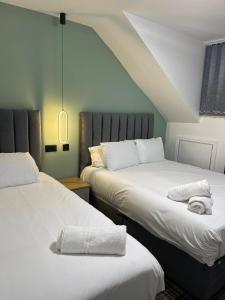 a bedroom with two beds with white sheets at Luis apartments in Leeds in Leeds