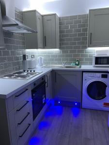 a kitchen with a stove and a washing machine at Luis apartments in Leeds in Leeds