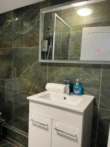 里茲的住宿－Luis apartments in Leeds，浴室设有白色水槽和镜子