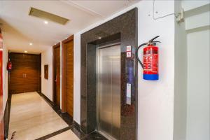 a fire extinguisher on the wall of a hallway at FabHotel Golden Home in Amritsar