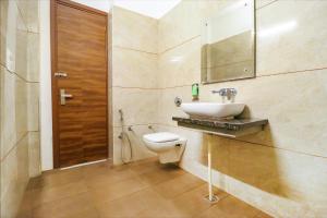 een badkamer met een toilet, een wastafel en een spiegel bij FabHotel Golden Home in Amritsar