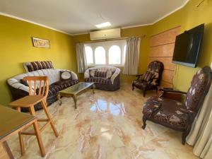 Al Crown في شرم الشيخ: غرفة معيشة مع أريكة وكراسي وتلفزيون
