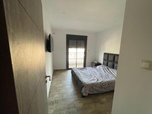 a bedroom with a bed and a television in it at Residence safwa in Oran