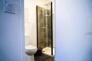 a bathroom with a toilet and a glass shower at Le Petit Marin • Cosy • Netflix & Wifi • Proche Centre-Ville in Châteauroux