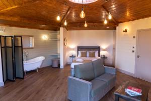 1 dormitorio con cama, bañera y sofá en Wildlands Galway en Moycullen