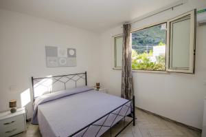 a bedroom with a bed and a window at Appartamenti da Clarissa in Macari