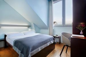 1 dormitorio con 1 cama, 1 silla y 1 ventana en Wedina Budget, en Hamburgo