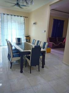 een eettafel en stoelen in de woonkamer bij Zarina's Budget Homestay in Tumpat